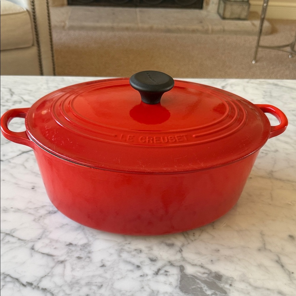 Le Creuset oval Dutch oven burnt orange reddish color. 
Never used.